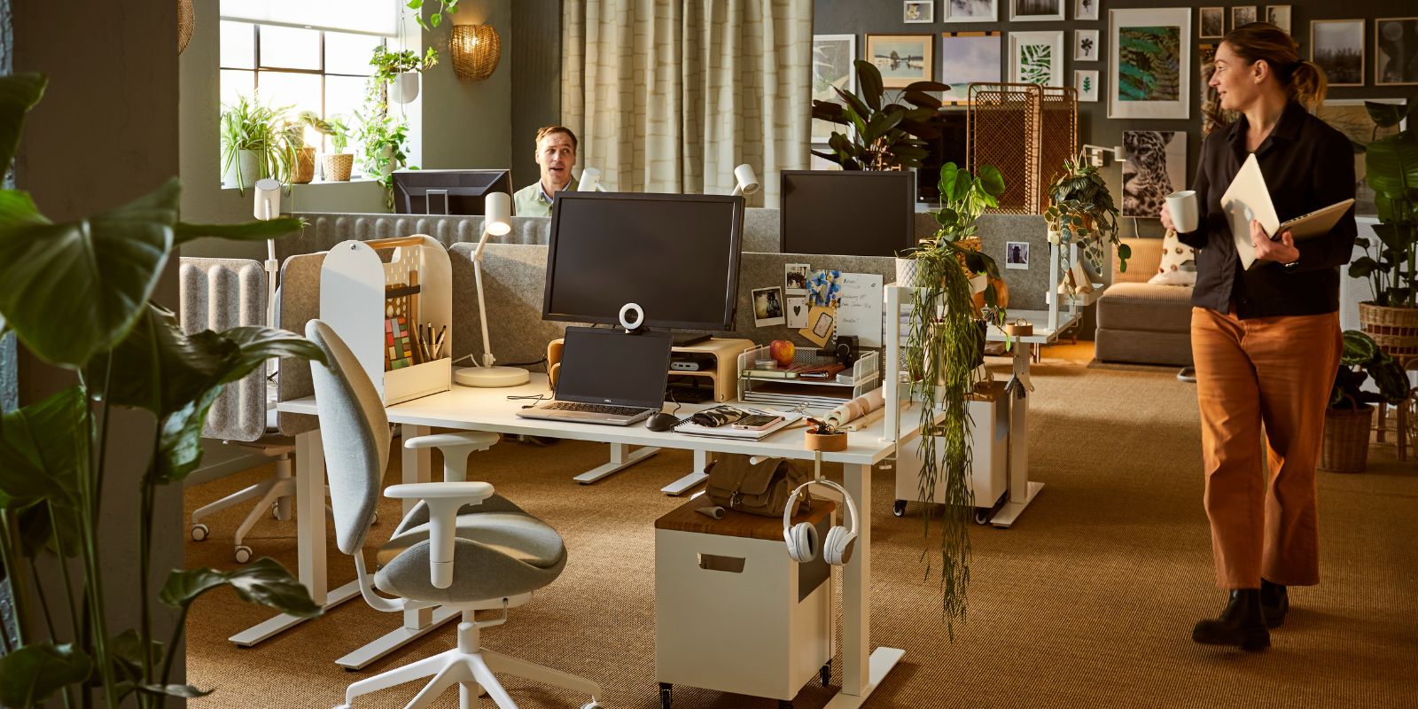 Warm office space with natural touches featuring TROTTEN desks, NYMÅNE lamps and VATTENKAR stands for a functional setup.