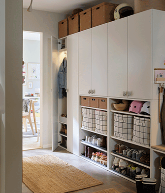 LASTARE wardrobe combinations with closed cabinets, baskets, helmets and shoe storage arranged neatly in a hallway.