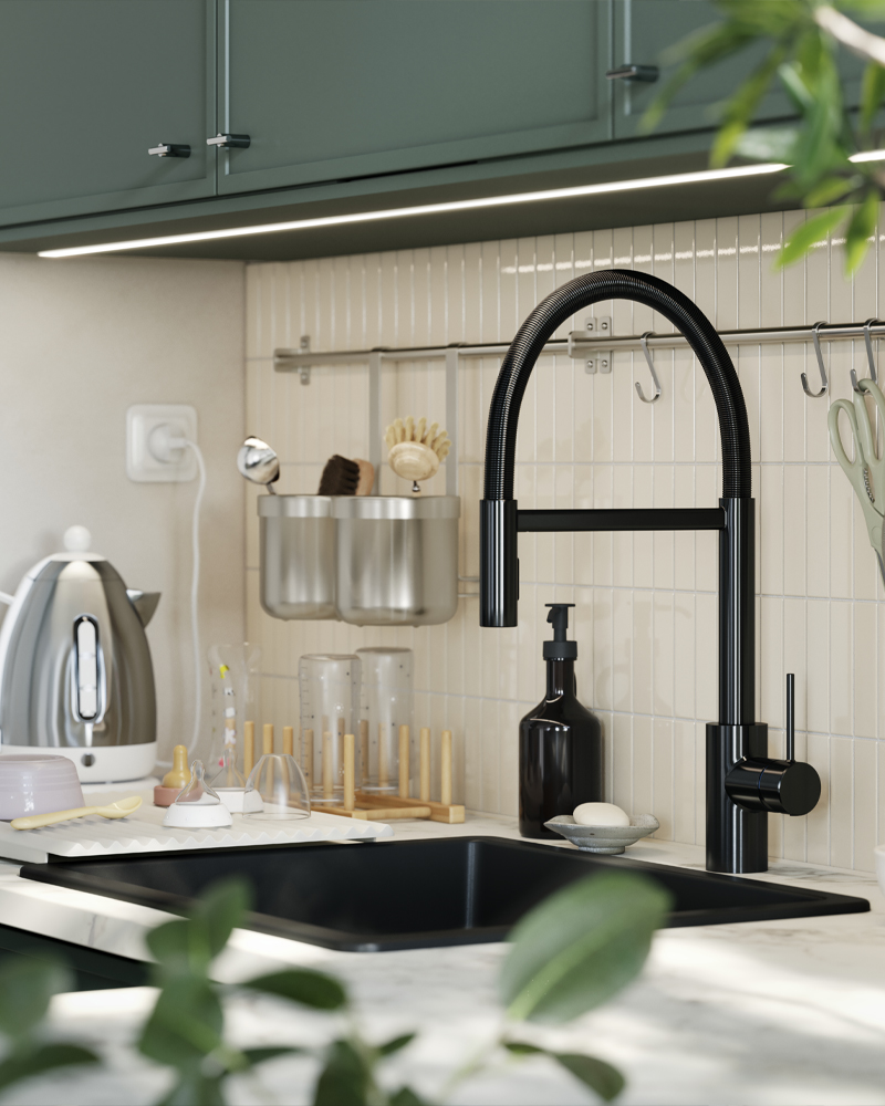 Un grifo monomando de cocina SALLSJÖN con diseño de cuello de cisne está instalado en una cocina con pared alicatada y puertas de cocina de color verde grisáceo.