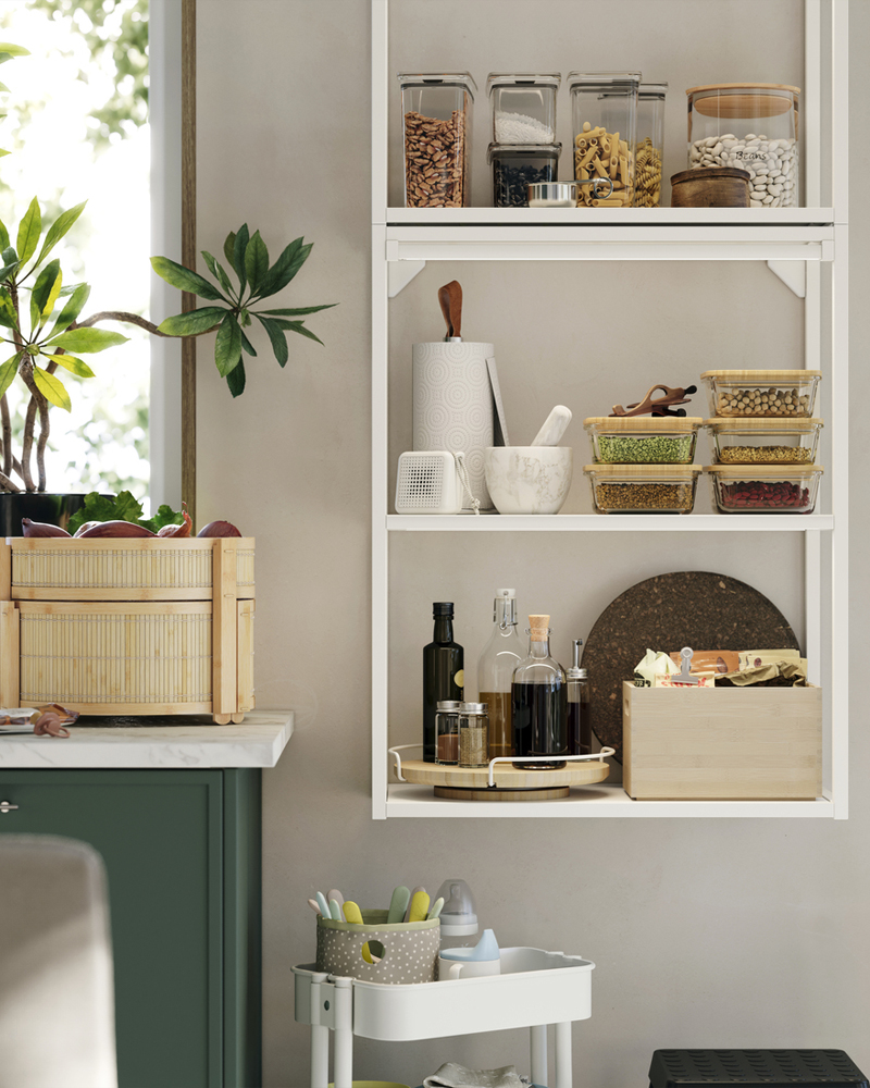 Un marco de pared ENHET está montado en la pared de la cocina y hay una cesta de bambú sobre la encimera, junto a él.