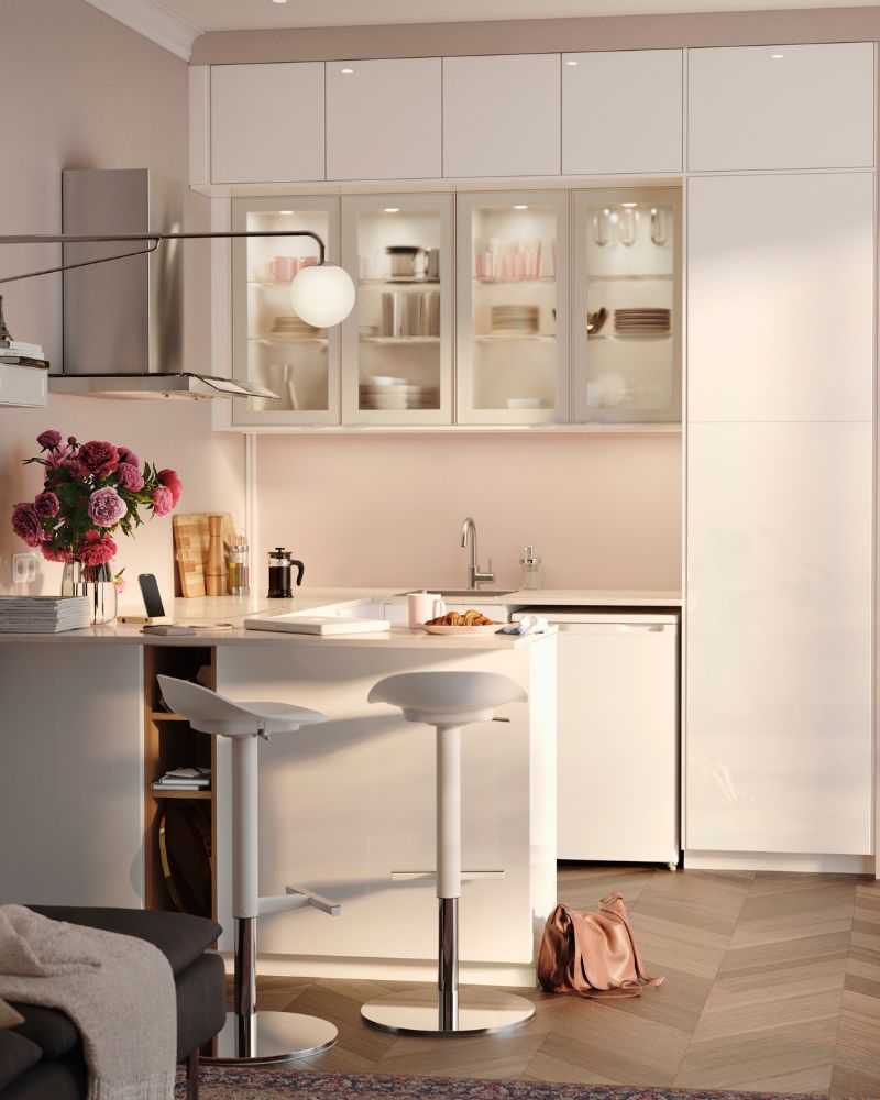A man watering the plants in his kitchen