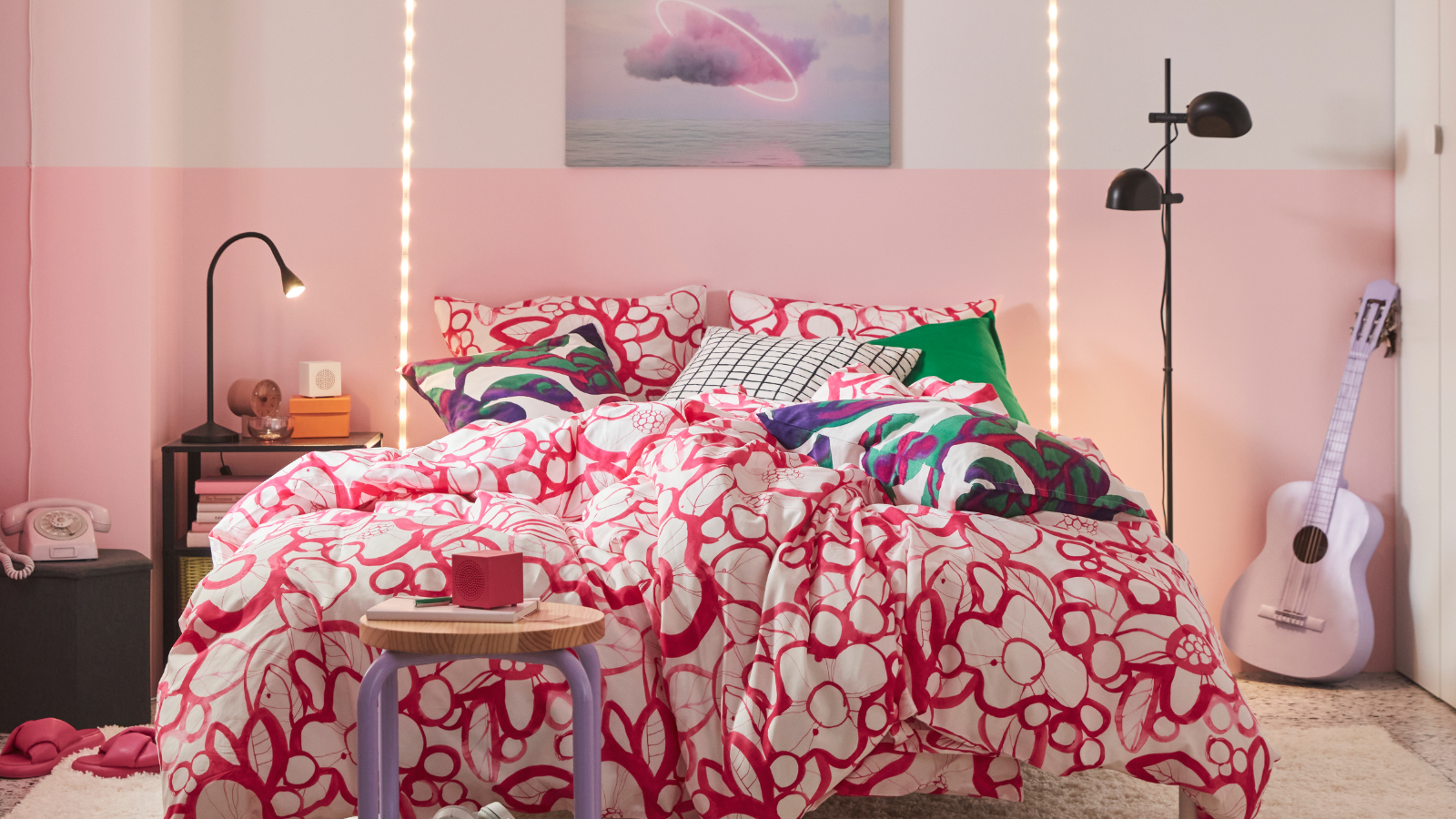 En este colorido dormitorio, la cama luce una funda nórdica y fundas de almohada HÄRLIR en blanco y rosa brillante con un estampado floral.