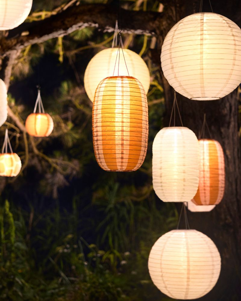 Warm garden lighting with a cozy feel, featuring SOLVINDEN hanging lamps that create a soft outdoor ambiance.