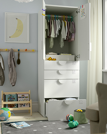 Armario solitario con puertas y cajones abiertos, juguetes alrededor