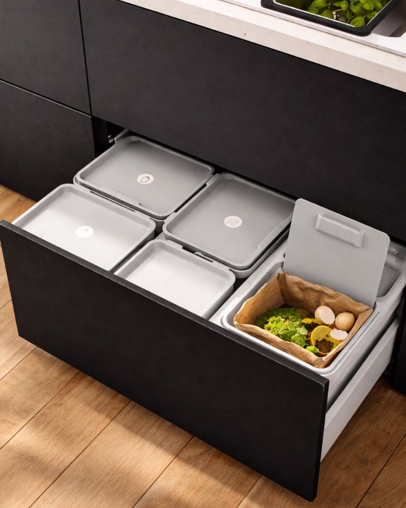 Almacenamiento moderno de cocina con frentes de cajón NICKEBO y solución HÅLLBAR para clasificar residuos en cajones.