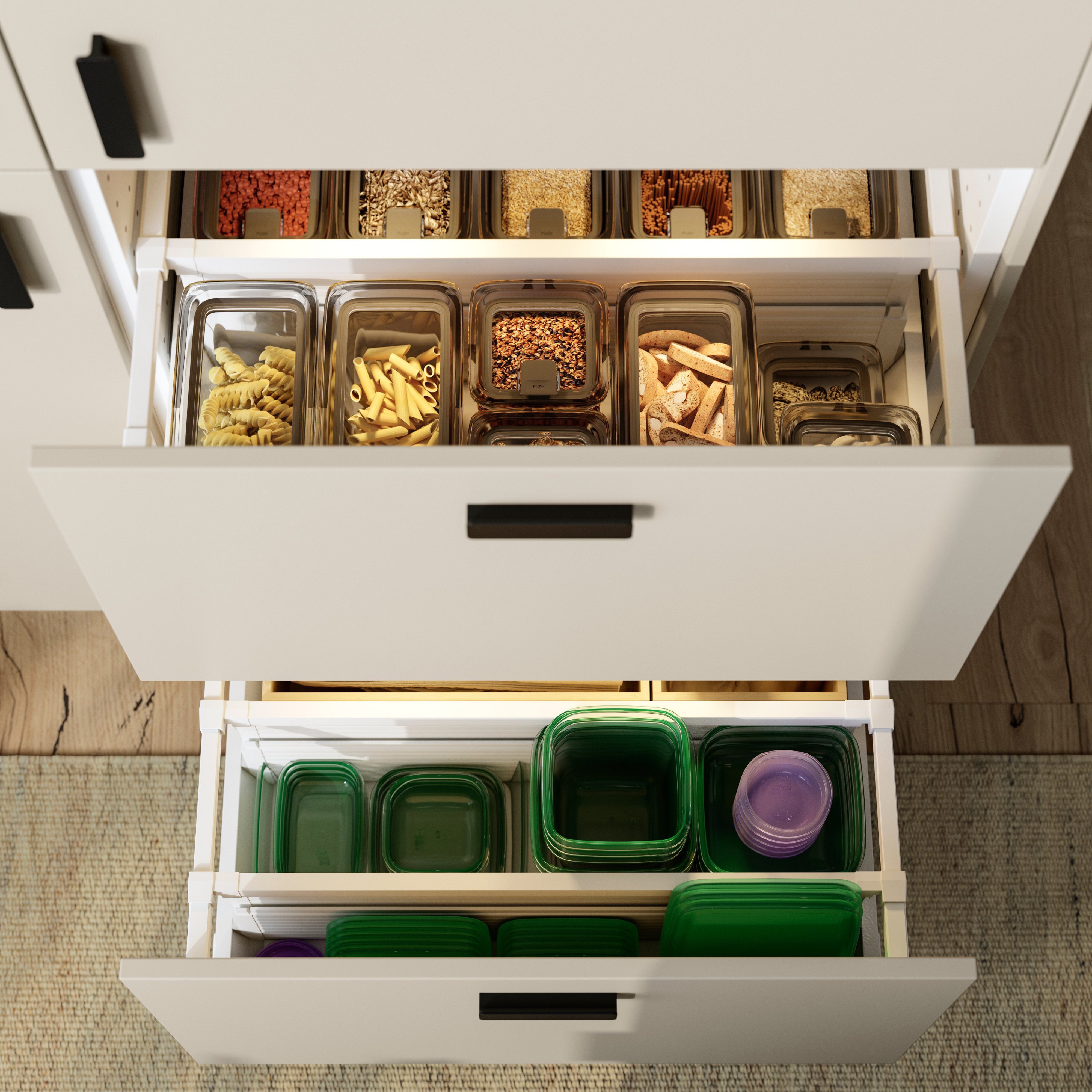 Open kitchen drawers with storage containers organizing pasta, grains, and plastic food containers.