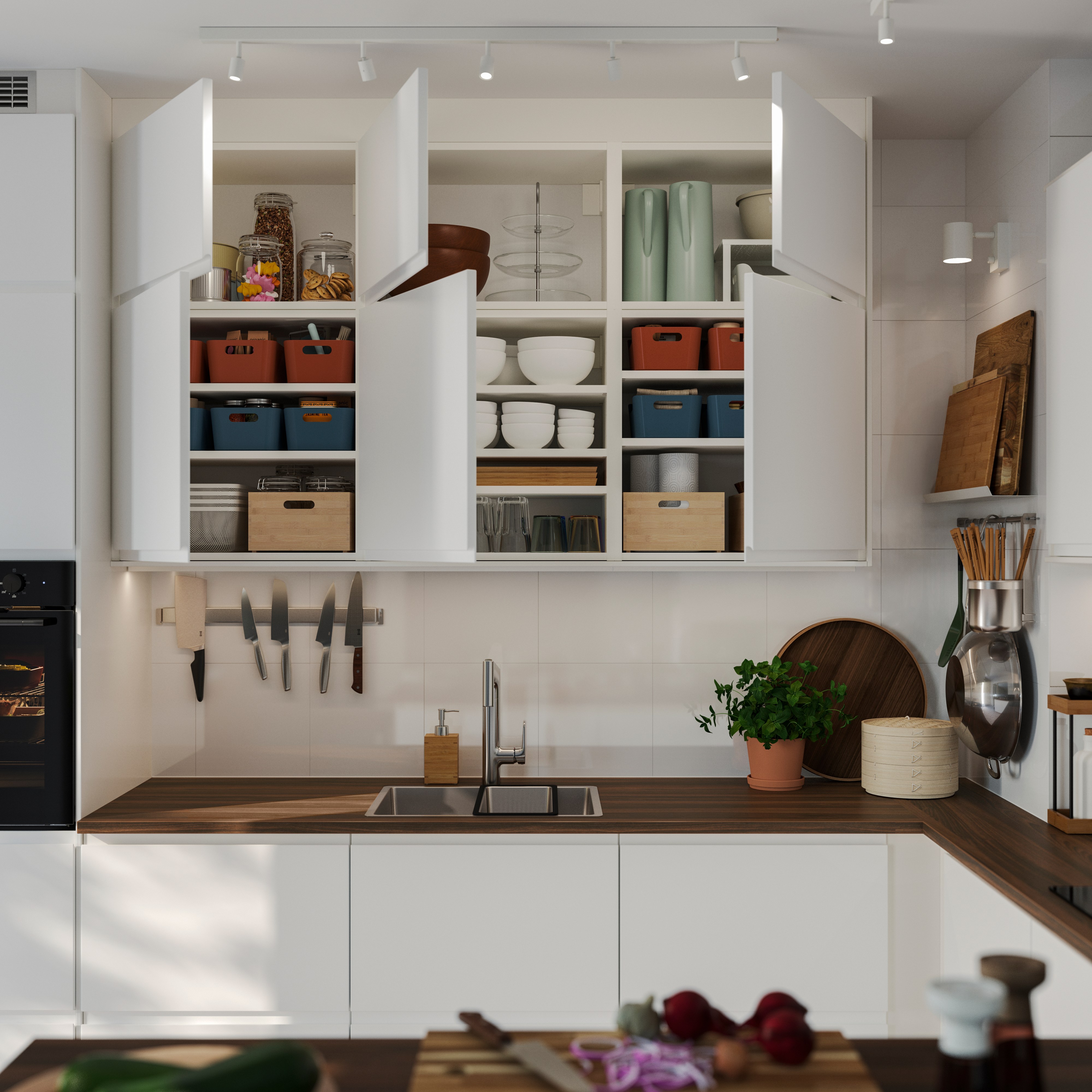 Open white kitchen cabinets with boxes, dishes, and utensils organized above the countertop.