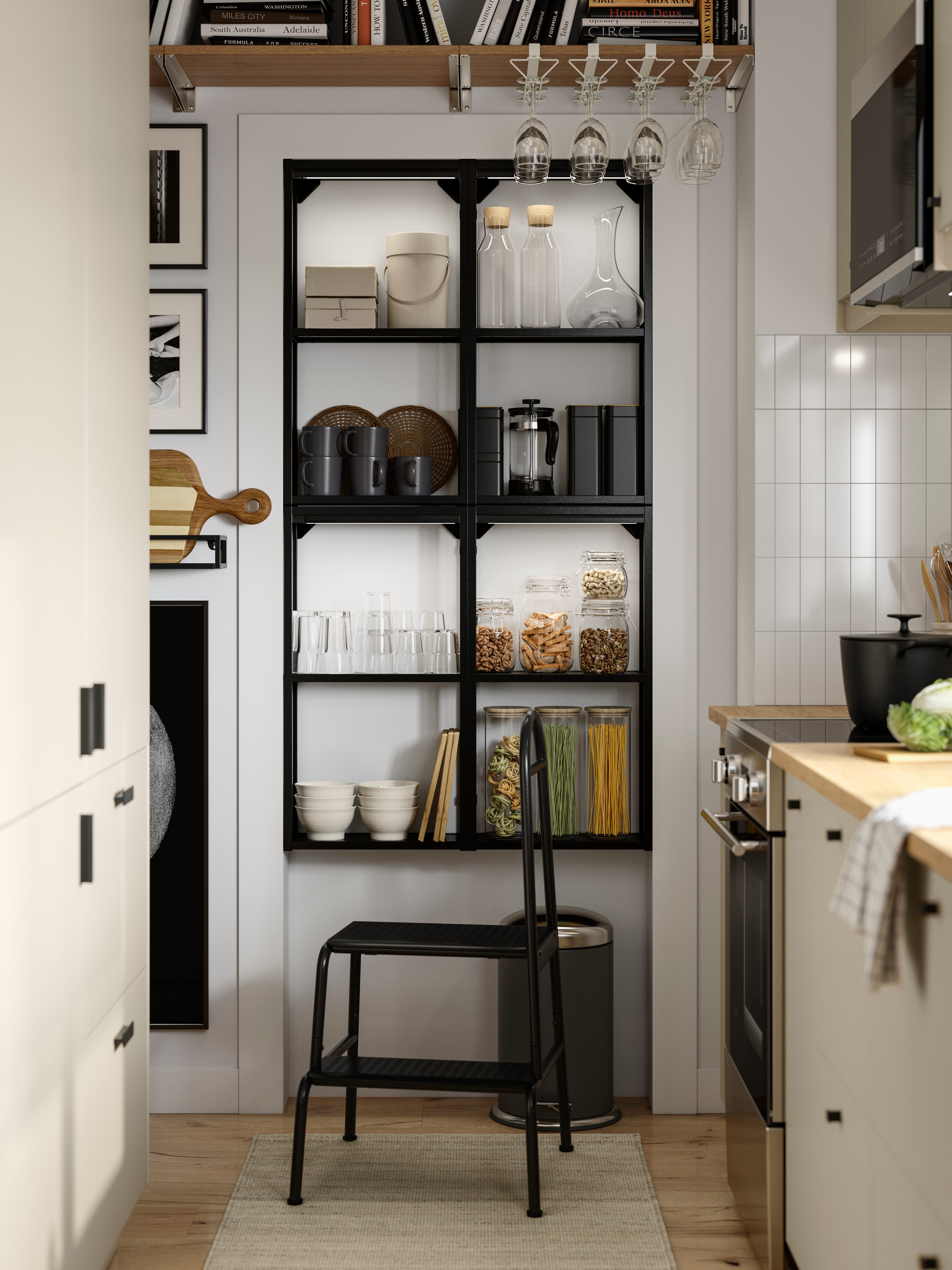 Black open kitchen shelving with jars of food, glasses, and neatly organized kitchen items.