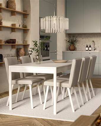 Modern dining room featuring a white table, beige upholstered chairs, and an elegant glass chandelier over a light rug.