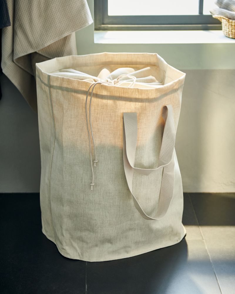 Minimal home corner with PURRPINGLA laundry bag for neat and flexible everyday storage.