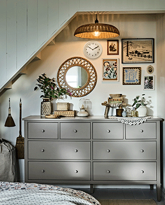 A sloped-ceiling bedroom area featuring a GULLABERG chest of 8 drawers with plants and decor arranged on top.