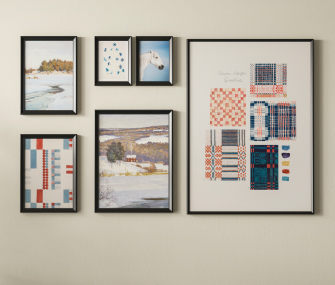 Set of black frames with abstract prints and landscape illustrations arranged as a gallery wall on a light-colored wall, in a minimalist setting.