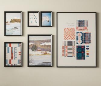 A neat arrangement of six black-framed pictures featuring winter landscapes, a horse, and textile design prints on a beige wall.