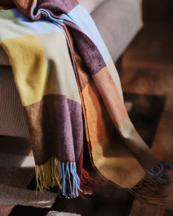 Cozy living room with SÖDERHAMN sofa, FLIKHAGTORN throw and MARKBLÅMME rug in warm autumn tones.