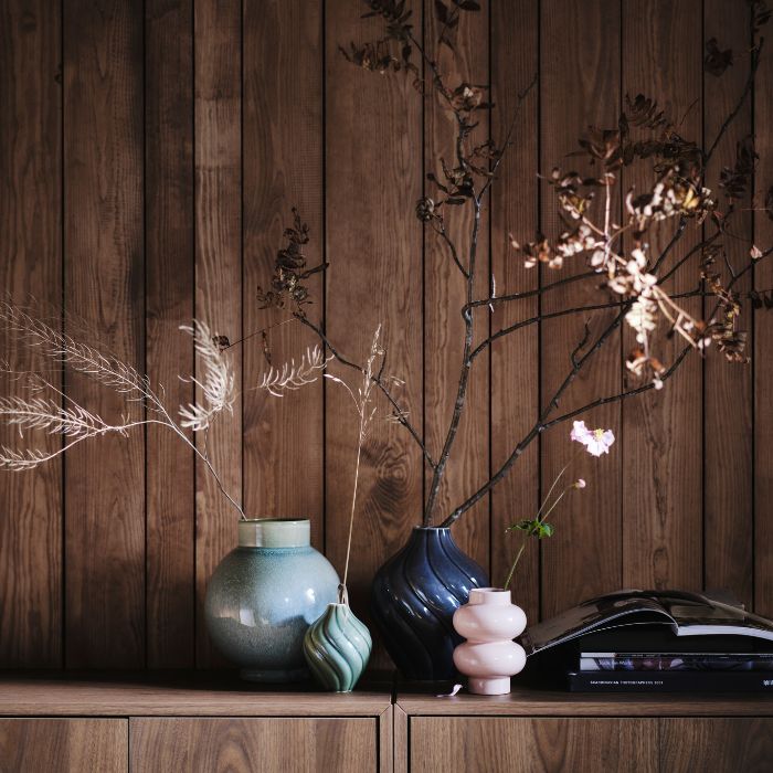 Decorative shelf with GLANSGRAN vase, KORNSPARV vases and PÄRLHÄGG vase in a warm natural setting.