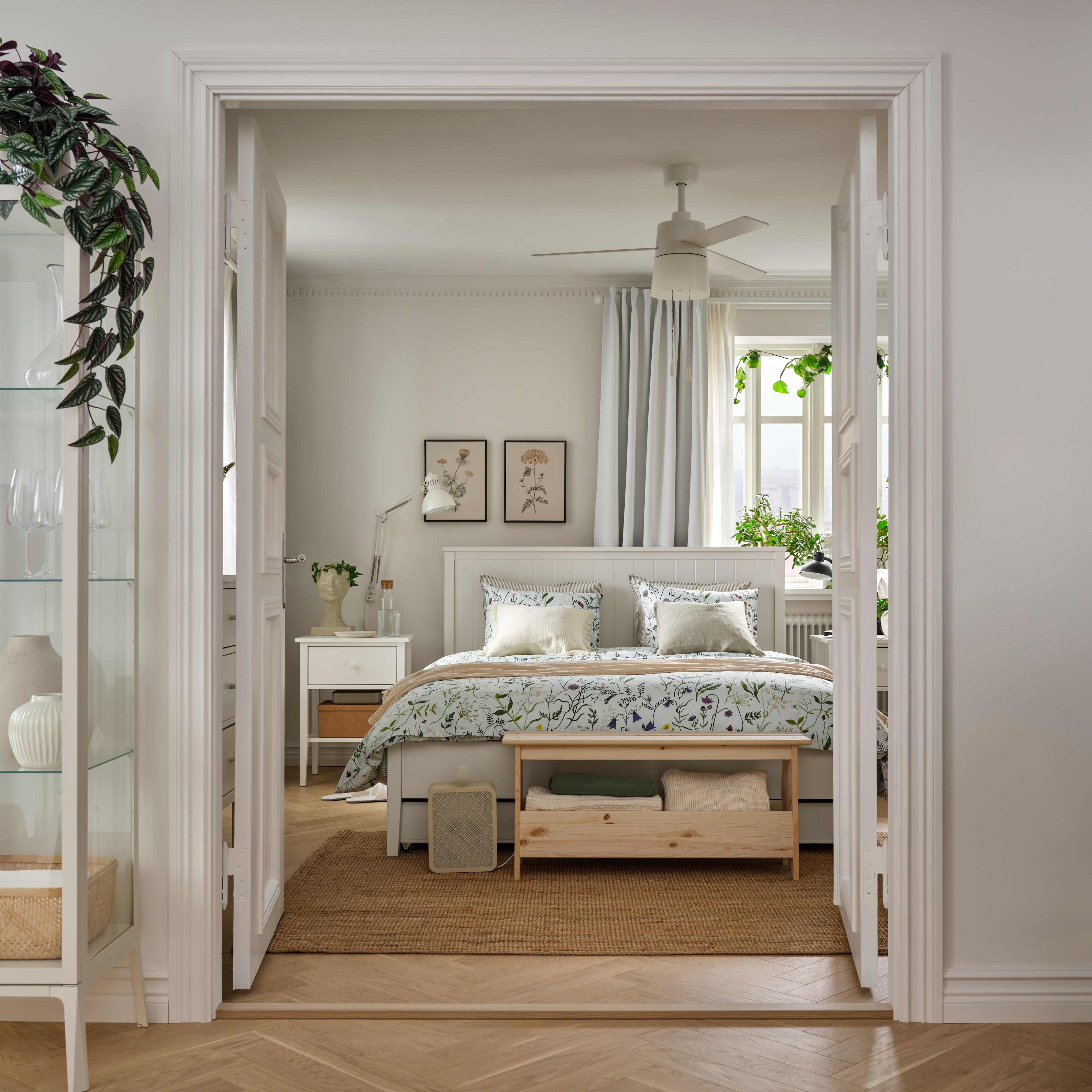 Bright bedroom with floral bedding and natural decor.