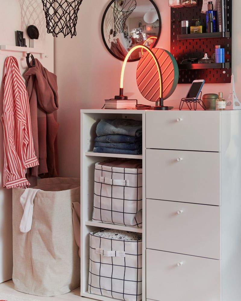 La habitación de un niño cuenta con una cómoda blanca LASTARE de cuatro cajones, con ropa cuidadosamente doblada y un espejo encima.