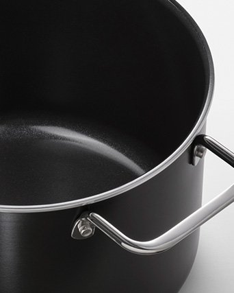 Olla negra con revestimiento antiadherente y mango metálico.