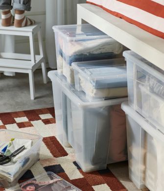 Zona de almacenaje práctica con cajas SAMLA, alfombra MARKBLÅMME, funda nórdica SLÅNHÖSTMAL y taburete BEKVÄM.