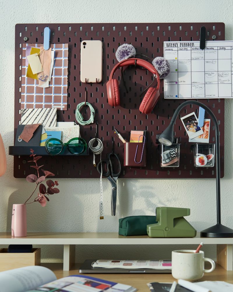 Área de trabajo organizada con tablero SKÅDIS, lámpara NÄVLINGE, mesa TRAVSPORT y florero FRÖVÄXT.