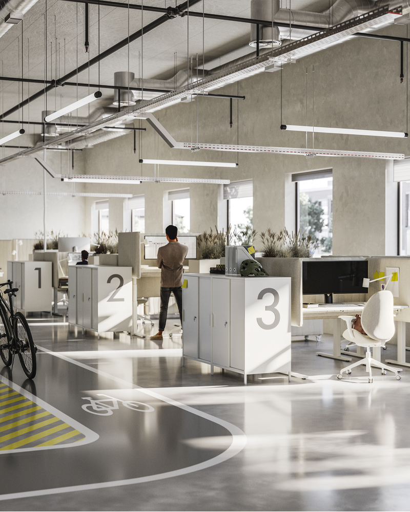 Tres filas de escritorios en una oficina diáfana y espaciosa. Cada puesto de trabajo cuenta con mamparas acústicas y sillas ergonómicas.