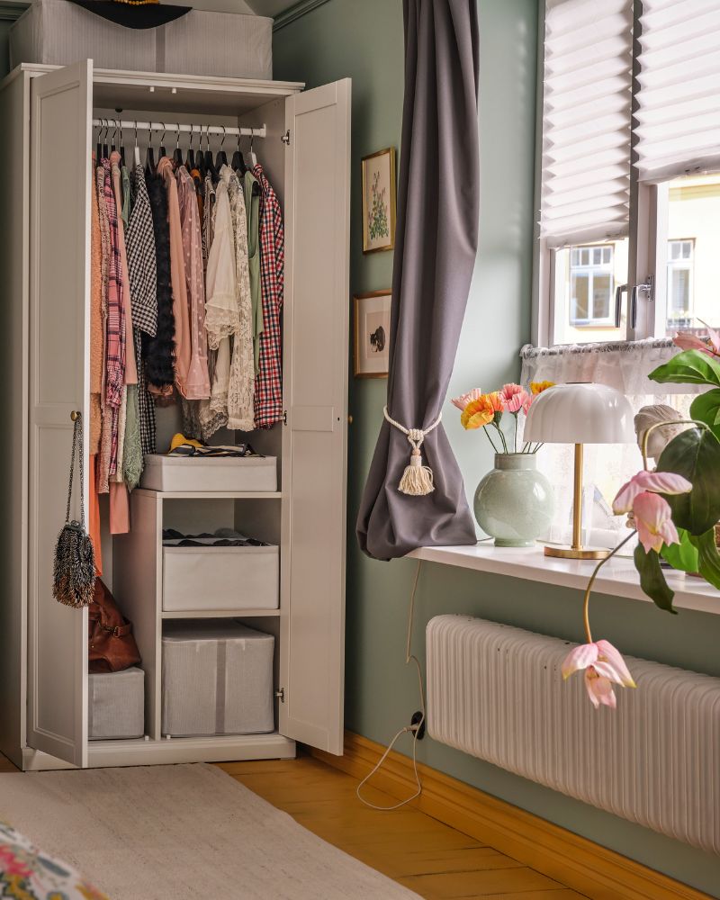 Functional wardrobe area with FÅGELFJÄLLET wardrobe, KORGMOTT curtains, AKTERSPRING lamp and GLANSGRAN vase.