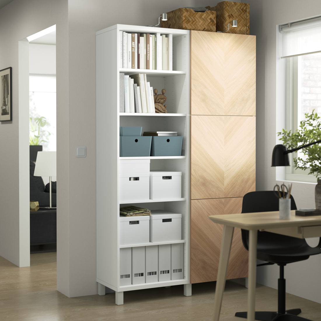 White shelving unit with books and storage boxes next to a desk.