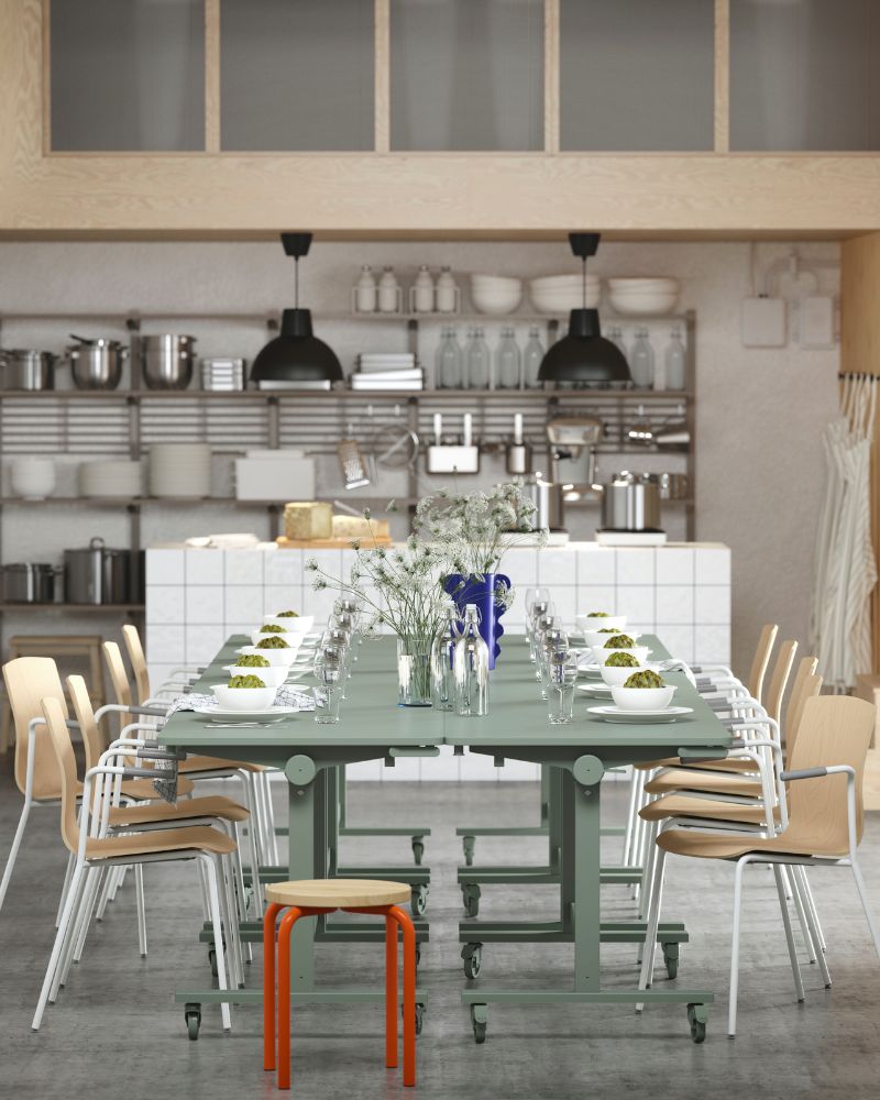Several green MITTZON tables arranged for dining, paired with LÄKTARE conference chairs and an orange/pine DOMSTEN stool