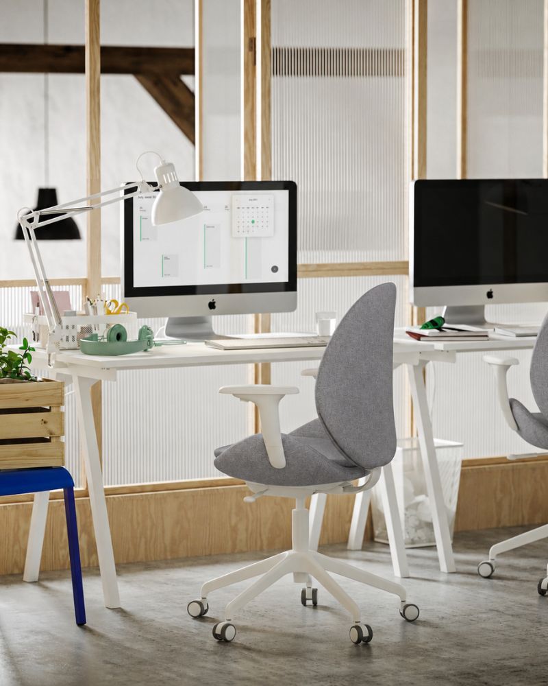 A small office with two white TROTTEN desks, light green/white HATTEFJÄLL conference chairs and white TERTIAL work lamps